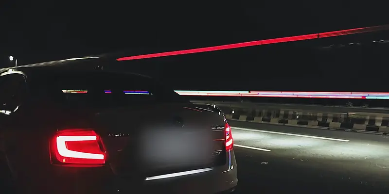Skoda Octavia tail light glowing red as traffic streaks past at night